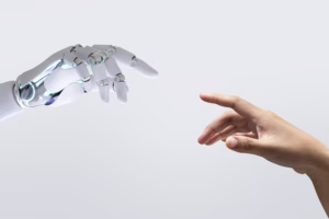 Image of a human hand reaching out towards a robotic hand representing pharma cobots assisting with manufacturing